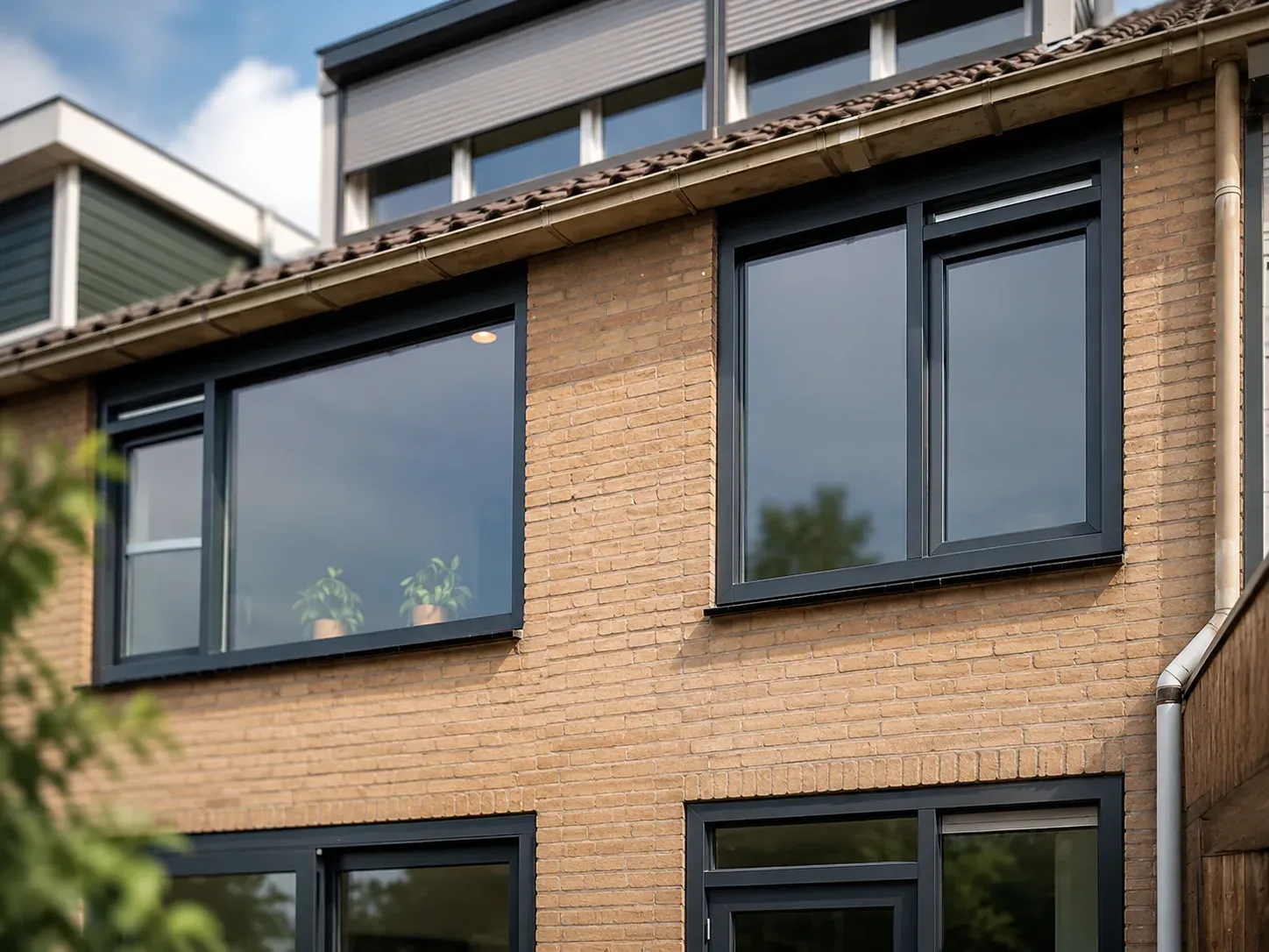 Nieuw antraciet kunststof kozijn met isolatieglas in een gemetselde gevel